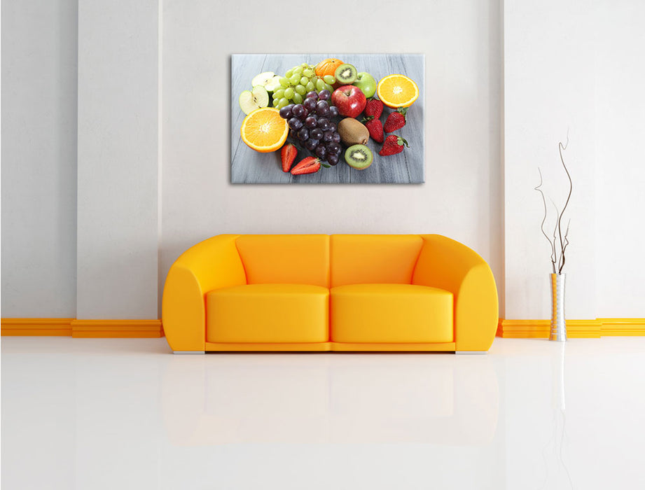 Obstmischung auf Holztisch Leinwandbild über Sofa