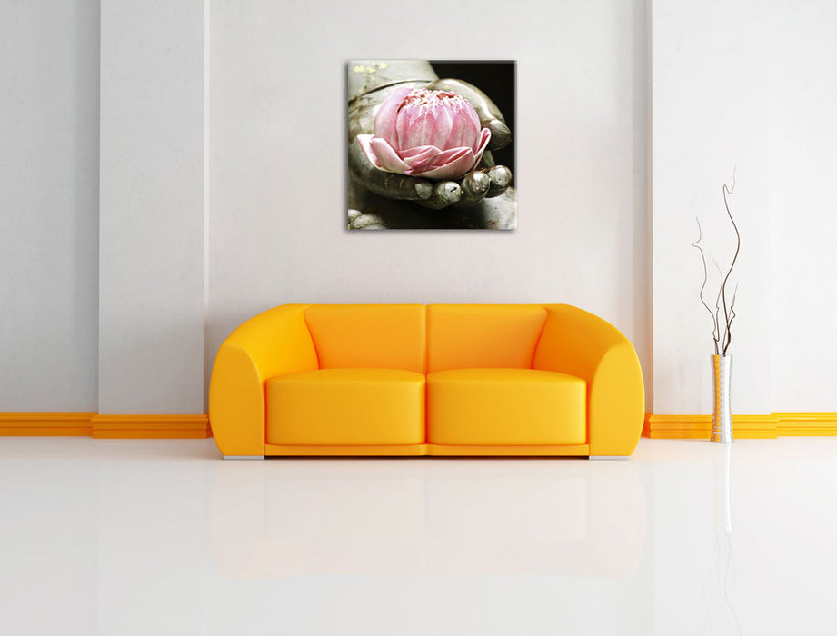 Lotus auf der Hand eines Buddhas Leinwandbild Quadratisch über Sofa
