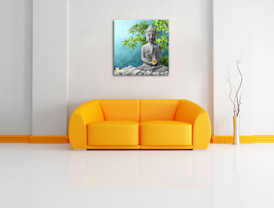 Buddha auf Steinen mit Monoi Blüte Leinwandbild Quadratisch über Sofa