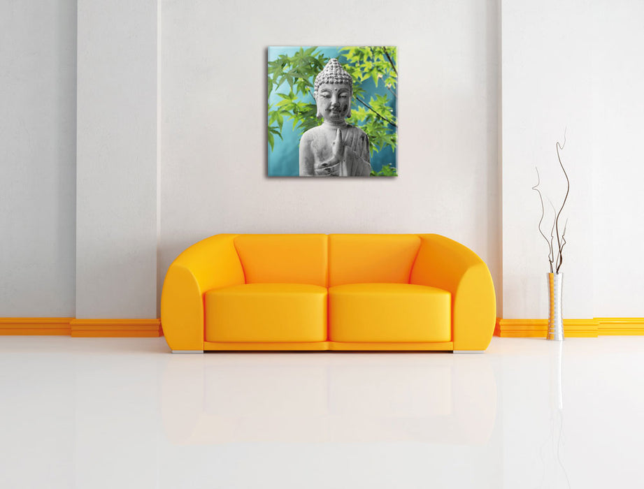 Buddha auf Steinen mit Monoi Blüte Leinwandbild Quadratisch über Sofa